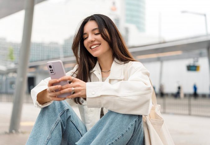 Lady smiles while reading something on phone